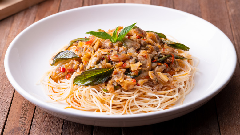 Thai noodle dish topped with chili and clam