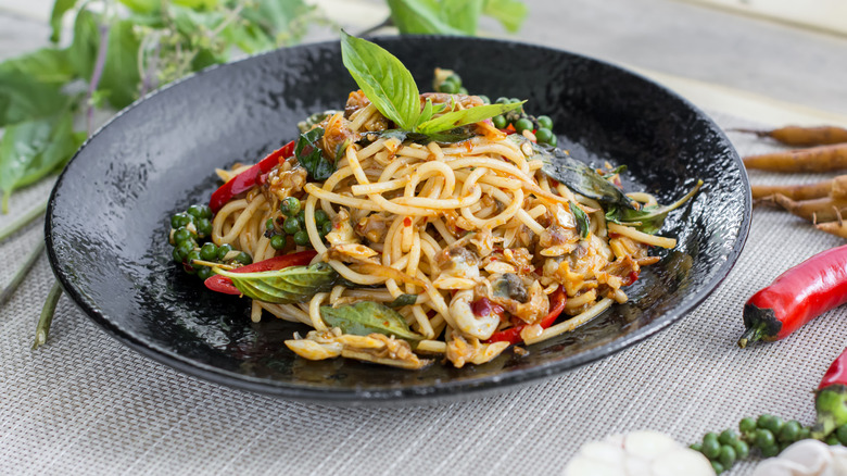 drunken clams and noodles on a black dish