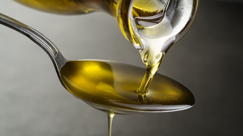 Olive oil being poured onto a spoon