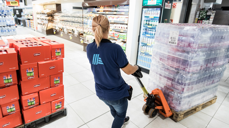 Aldi employee pulling pallet of goods