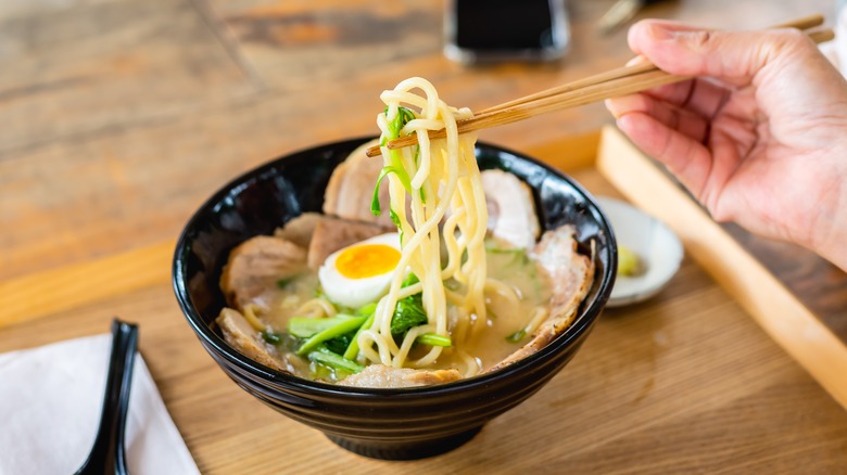 Person eating bowl of ramen