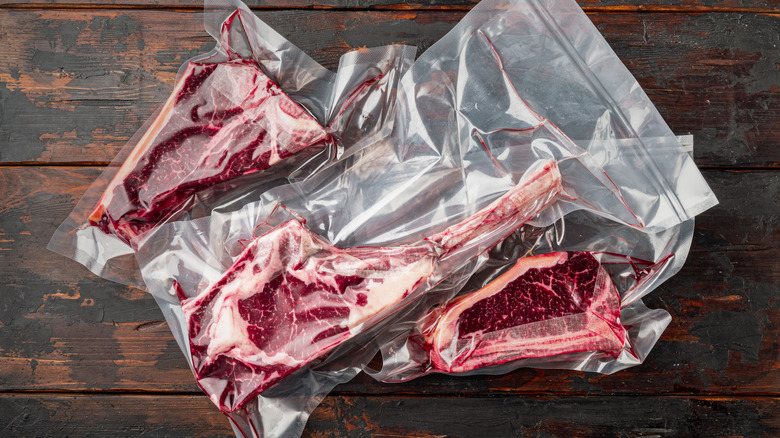 Vacuum sealed steaks on a brown table