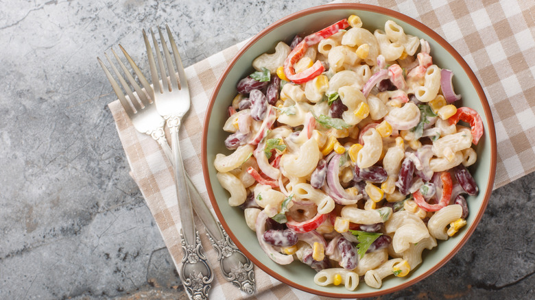 Creamy pasta salad with veggies on a checkered napkin
