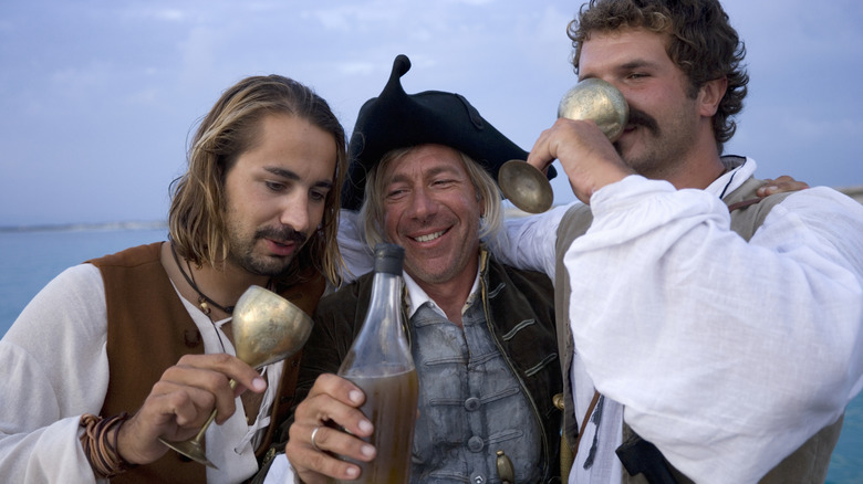 Pirates drinking alcohol near the ocean