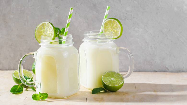 Two glasses of creamy limeade with lime and mint leaves for garnish