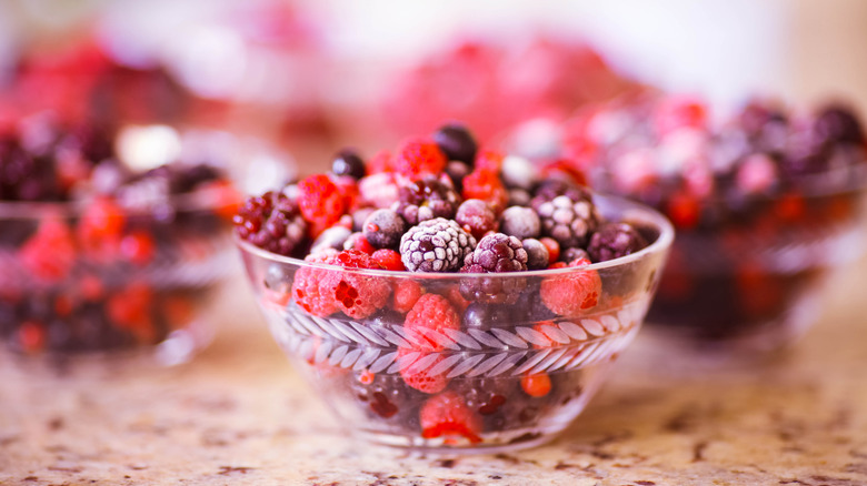 Glass bowl full of frozen summer fruits