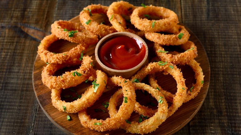 Round onion rings platter with tomato sauce in the middle.