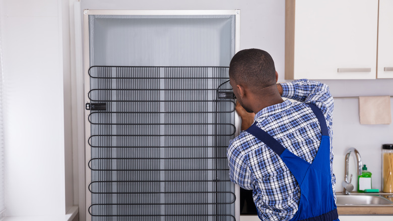 Man working on refrigerator coils