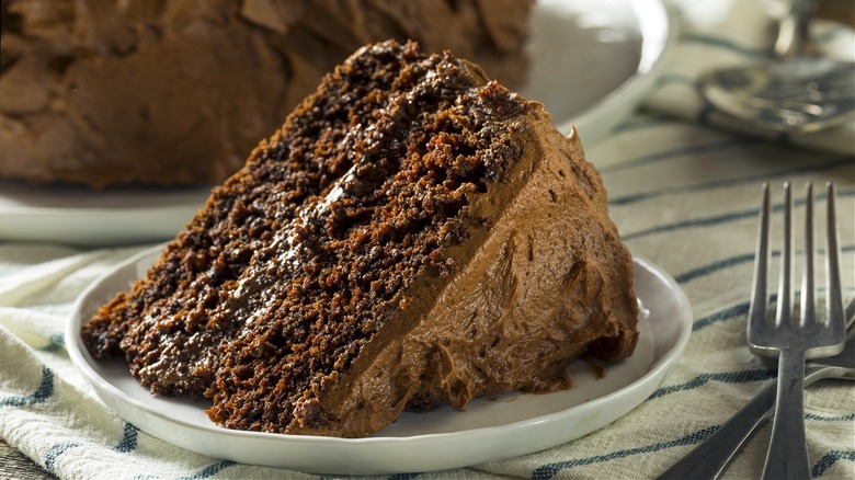 Chocolate cake slice on a plate with a fork