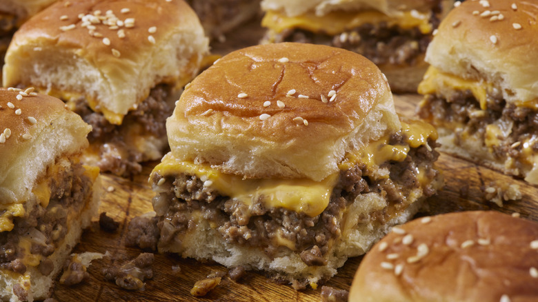 Slider burgers with melted cheese, on a wooden board