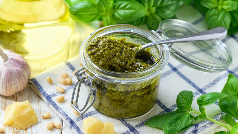 Jar of pesto, surrounded by pesto ingredients