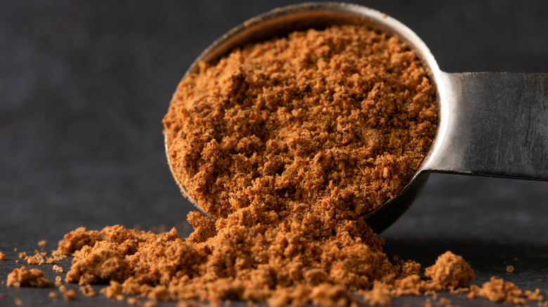 Taco seasoning spilling from a measuring spoon