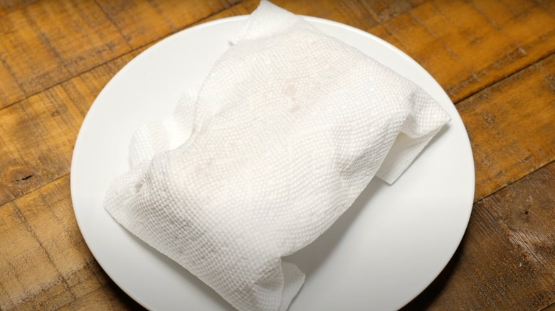 Frozen slider wrapped in a paper towel, sitting on a white plate