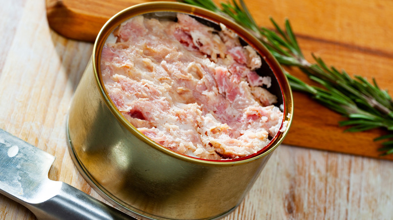 Canned ham, with sprig of rosemary behind it