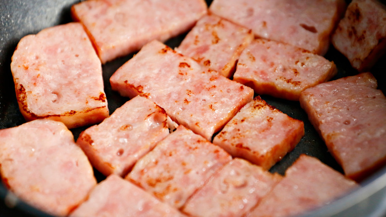 Sliced canned ham being cooked