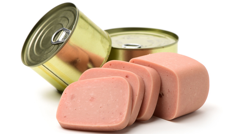 Sliced canned ham next to cans