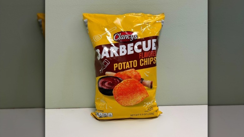 A bag of Clancy's Barbecue Chips on a green and white background